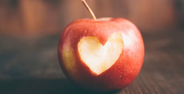 Photo of an apple with a heart-shaped bite in it