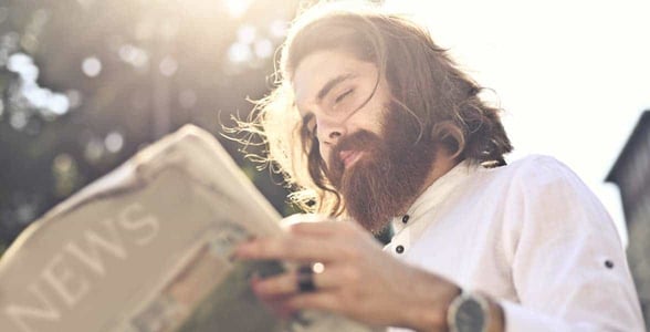 Photo of a man reading a newspaper
