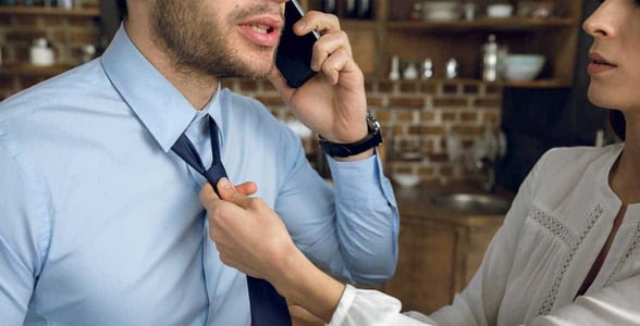 Photo of a woman tying a man's tie Photo of a woman tying a man's tie