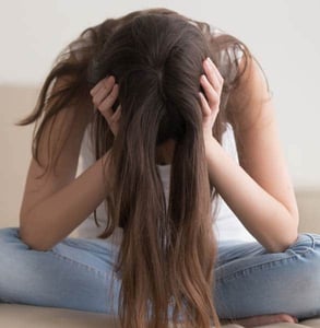 Photo of a woman with her head in her hands