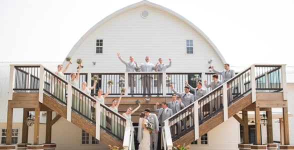 couple kissing surrounded by bridal party