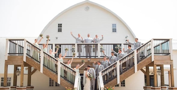 couple kissing surrounded by bridal party couple kissing surrounded by bridal party