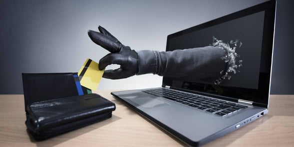 hand reaching into wallet through computer