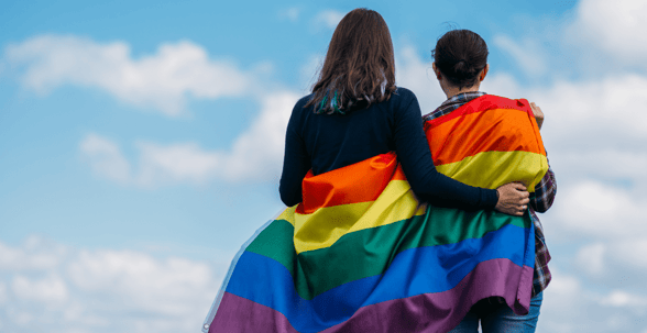 two people wrapped in pride flag
