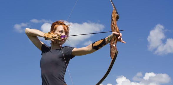 woman shooting bow and arrow