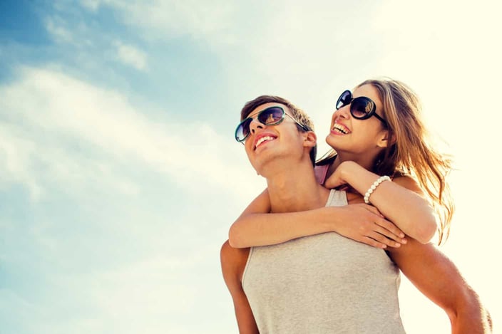 holidays, vacation, love and friendship concept - smiling couple having fun over sky background holidays, vacation, love and friendship concept - smiling couple having fun over sky background