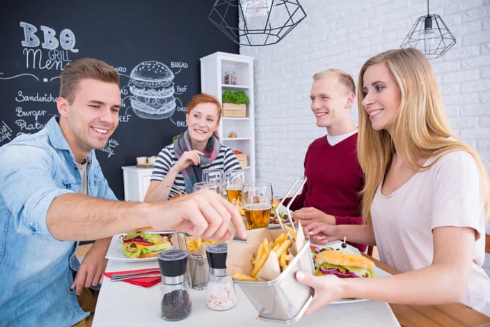 Girl is sharing with fires to her friend at the table