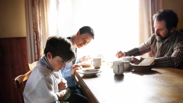 Angry small girl with parents sulking indoors at the table at home, poverty concept. Angry small girl with parents sulking indoors at the table at home, poverty concept.