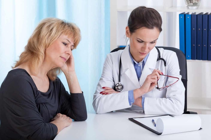 Young internist having bad news for a female patient Young internist having bad news for a female patient