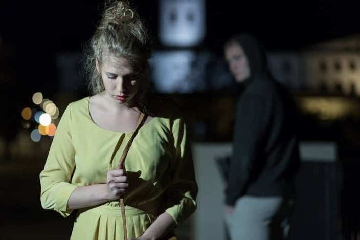 Criminal observing young woman walking alone at night