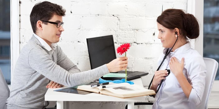 Man giving doctor a flower