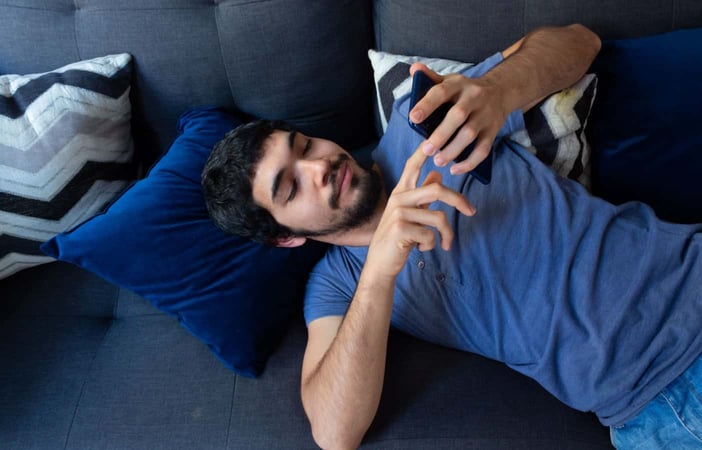 Man laying down looking at phone Man laying down looking at phone