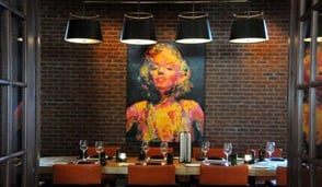 painting on wall behind large dining table