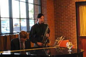man plays saxophone by pianist