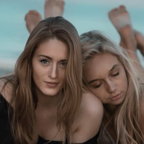 two women, embracing, one placing head on other's shoulders