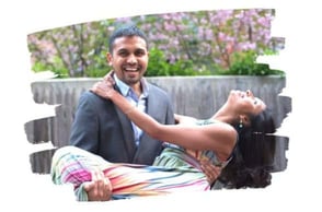 man holds woman in his arms, both smiling