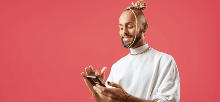 Non-binary person smiling and texting on a cellphone Non-binary person smiling and texting on a cellphone