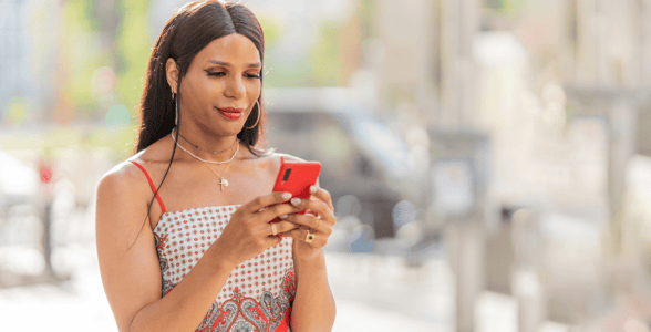 Transgender woman looking at cellphone