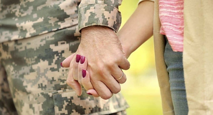 Photo of service member holding hands with a date