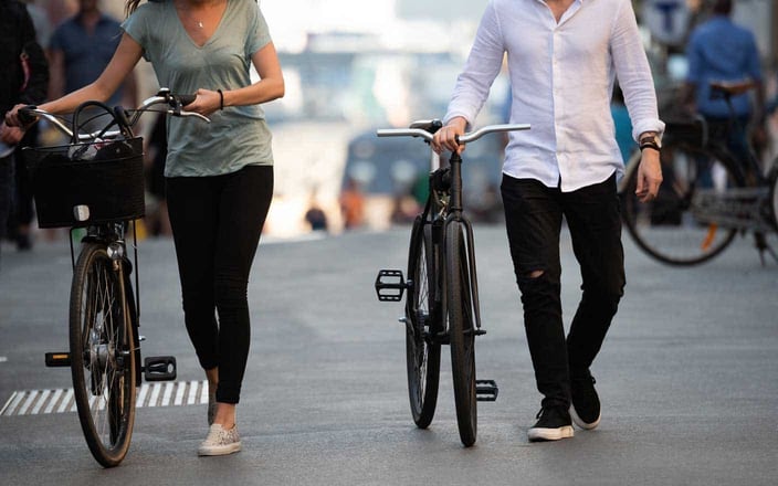 Photo of couple walking bikes