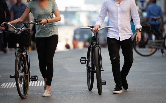 Photo of couple walking bikes Photo of couple walking bikes
