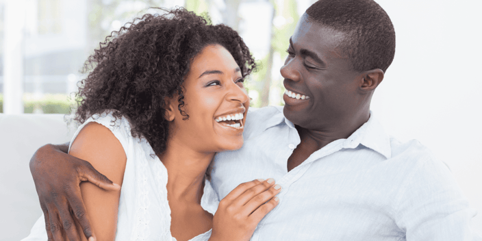 Black man and woman couple smiling at each other in love