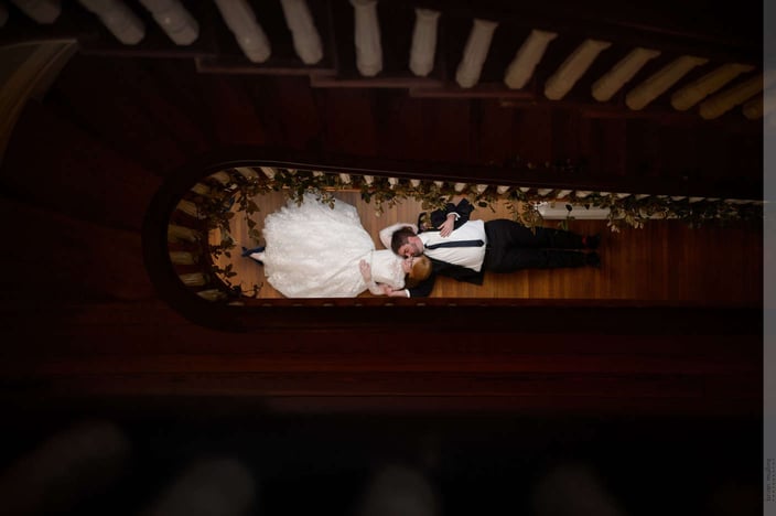 Bride and groom laying in a stairwell together