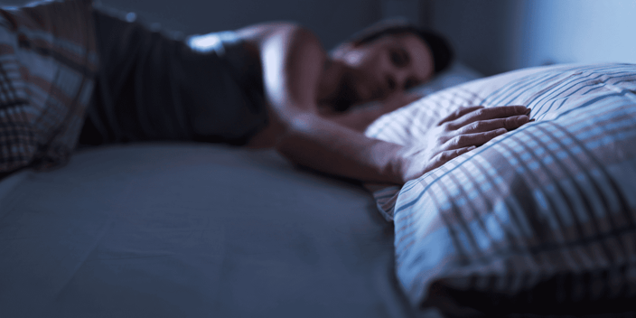 Young woman sleeping holding right arm on empty pillow beside her Young woman sleeping holding right arm on empty pillow beside her