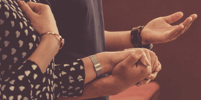Man and woman praying and holding hands in church Man and woman praying and holding hands in church