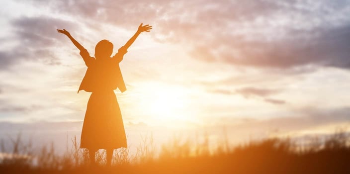 woman standing looking at sun triumphantly woman standing looking at sun triumphantly