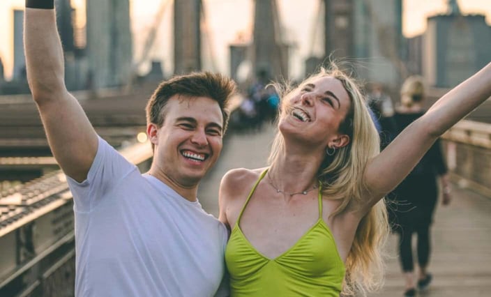 Man and woman laughing together arms in the air Man and woman laughing together arms in the air