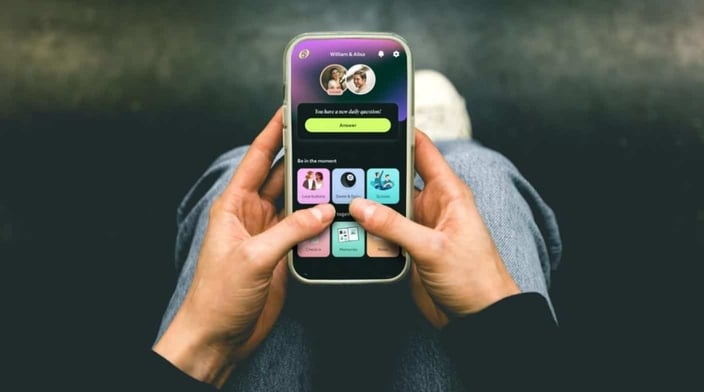Person holding phone using Official app Person holding phone using Official app