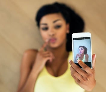 Young woman filming selfie yellow tank top Young woman filming selfie yellow tank top