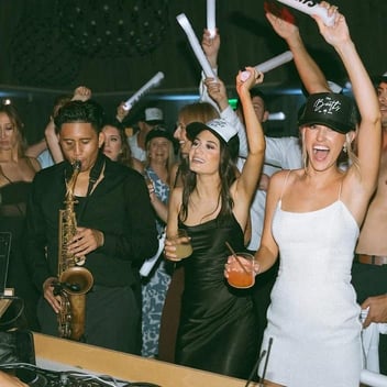Wedding guests partying with saxophone player