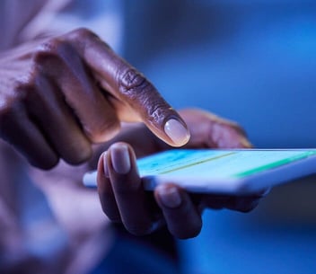 Woman typing on phone with one finger blue light