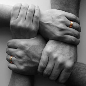 Four hands linking wedding rings