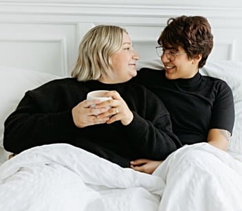 Couple with black shirts cuddling in bed Couple with black shirts cuddling in bed