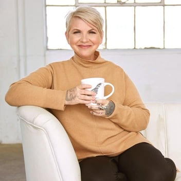 Zoë Kors holding mug on chair Zoë Kors holding mug on chair