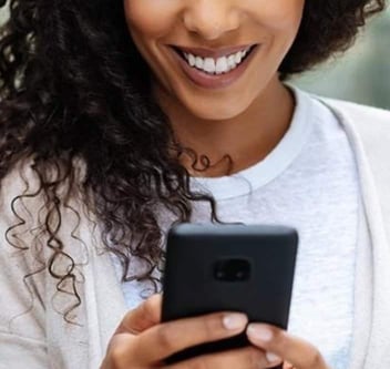 Woman smiling down at phone Woman smiling down at phone