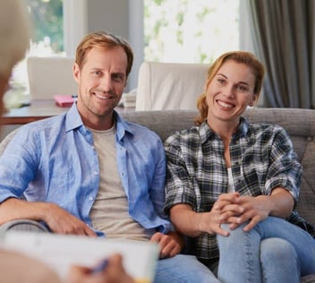 Photo of young couple smiling during a therapy appointment