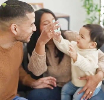 Photo of a young couple playing with their toddler
