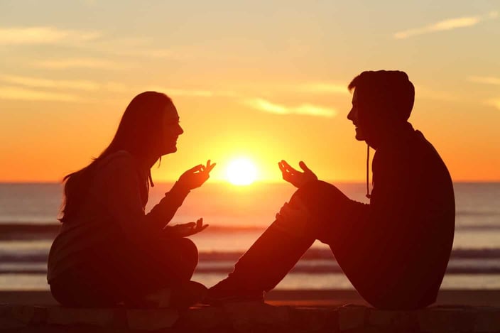 Introductions, Inc. couple at sunset beach talking to each other