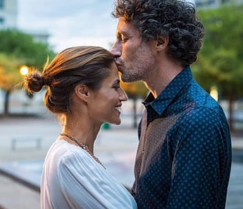 A photo of a man kissing his girlfriend on the forehead
