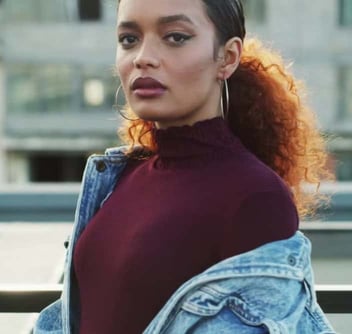 Photo of a young woman wearing a red shirt and denim jacket looking seriously at the camera Photo of a young woman wearing a red shirt and denim jacket looking seriously at the camera