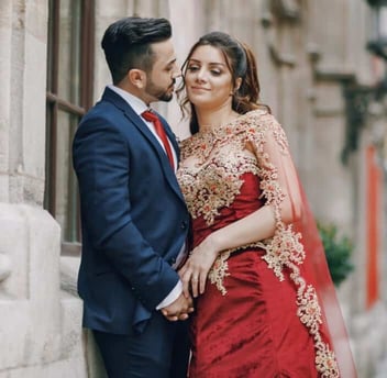 Photo of an Indian couple cuddling and posing for a photo together outdoors