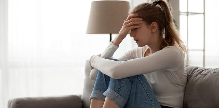 woman with hand on head, looking frustrated