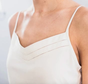 Close-up photo of a young woman wearing a white silk slip Close-up photo of a young woman wearing a white silk slip