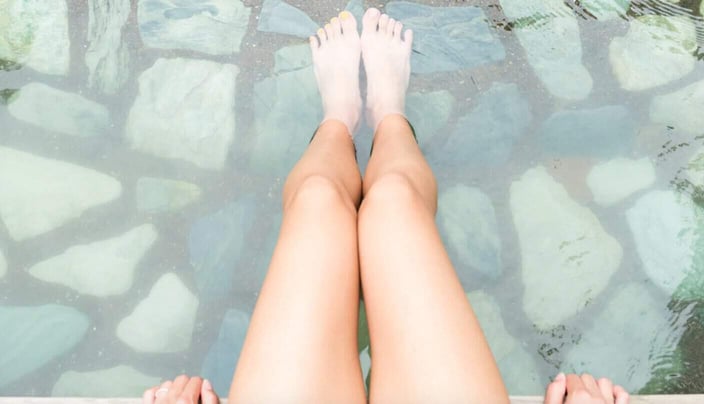 Screenshot of young woman soaking her bare feet in a body of water Screenshot of young woman soaking her bare feet in a body of water