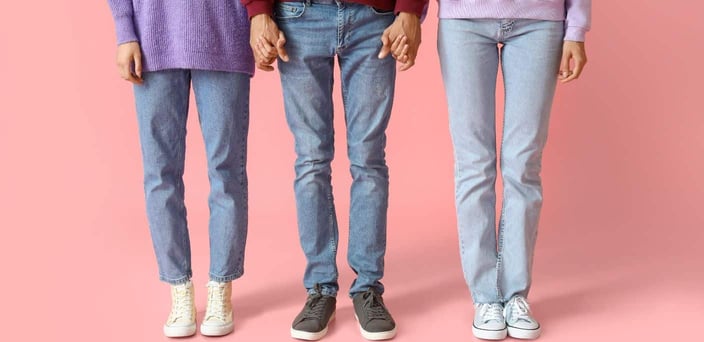 Waist down shot of three people holding hands.