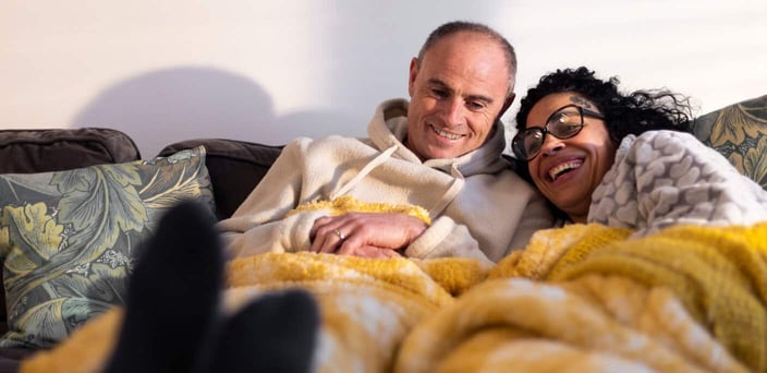 Couple cuddling under blankets Couple cuddling under blankets